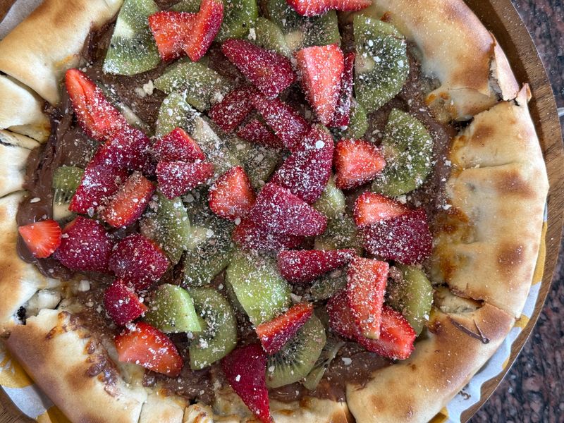 Nutella dessert pizza with fresh strawberries and powdered sugar